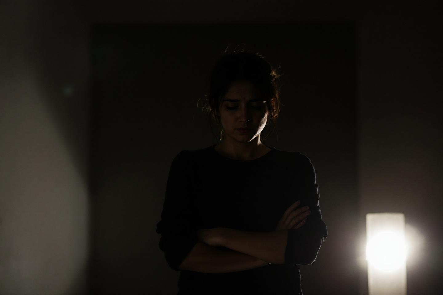 Silhouette sombre d'une personne les bras croisés